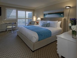 Resort room with bed and desk and dresser