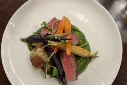 beef dish in cabin with colourful carrots on table