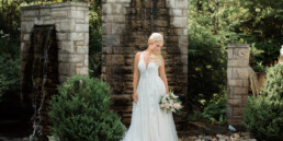 Woman in wedding dress standing in front of waterfall